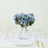 Blue floral arrangement in glass vase on dining table