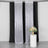 Sparkling silver curtains with black backdrop and floral arrangement on a pedestal.