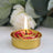 Decorative rose-shaped candle with a burning wick and gold accents.