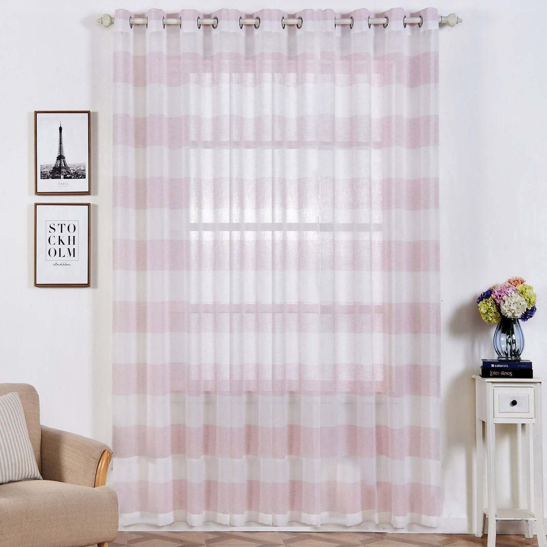 Sheer striped pink and white curtains hanging in a stylish living room setting.