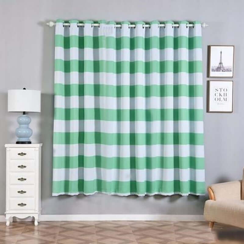 Green striped curtain hanging in a stylish room with furniture and decor.
