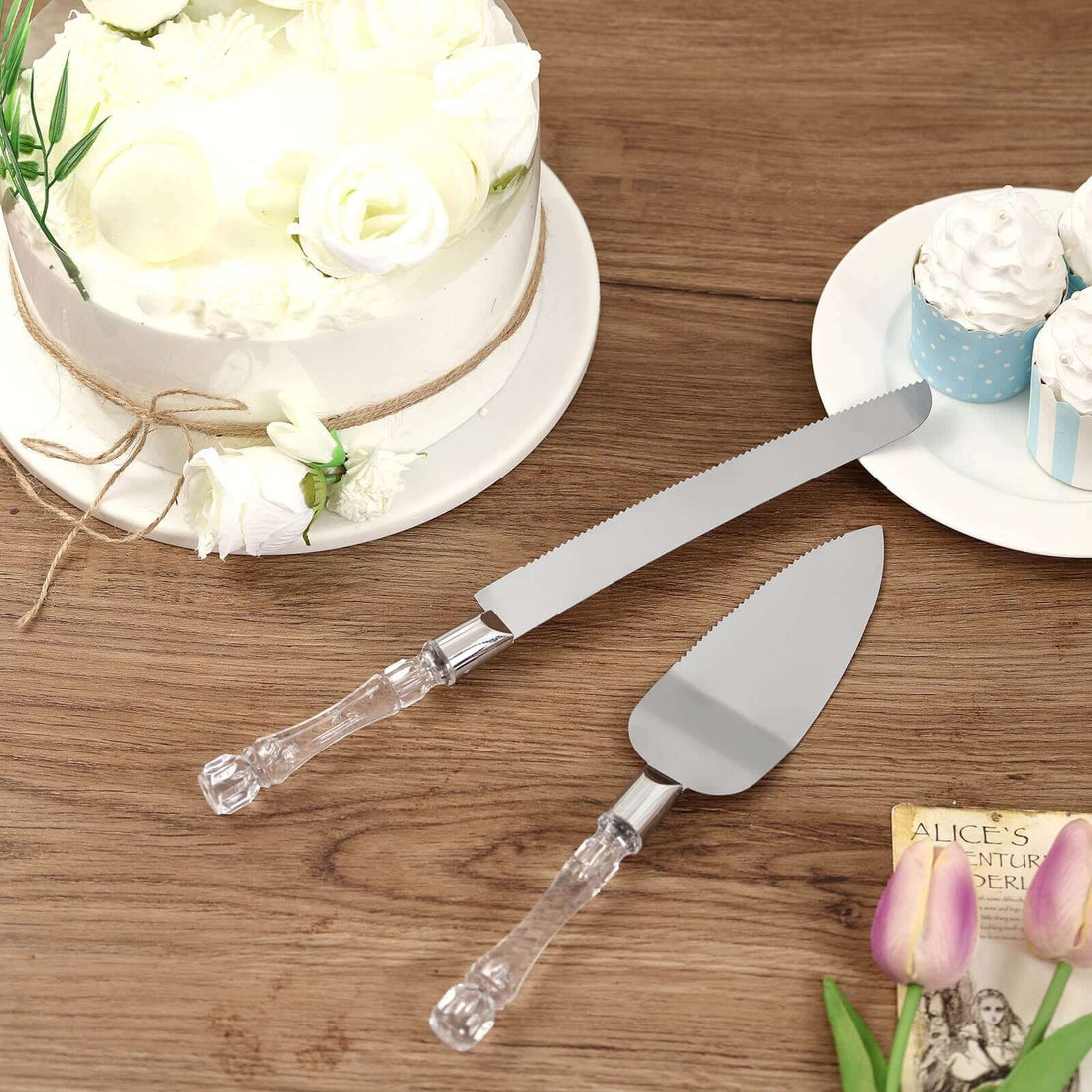 Cake serving set with clear handles on a wooden table.
