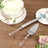 Cake serving set with clear handles on a wooden table.