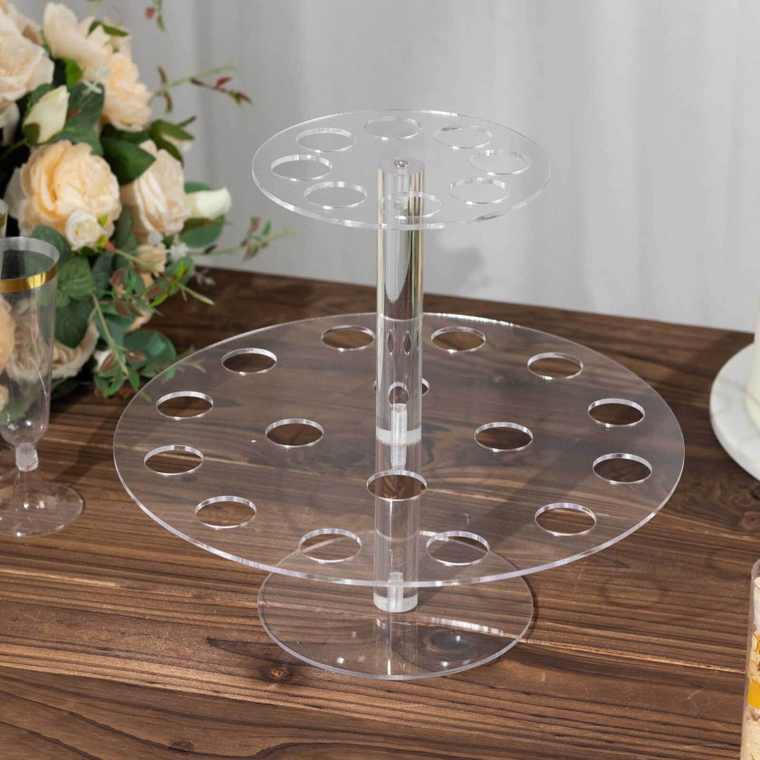 Clear acrylic cupcake stand with multiple tiers and holes for display.