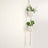 Hanging macramé plant holder with white pots and greenery
