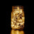 Mason jar filled with warm white fairy lights glowing in the dark. #whtbkgd