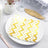 Gold and white zigzag patterned paper napkin on a plate.