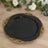 Elegant black plate with gold ornate trim on a wooden surface.