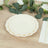 Elegant cream-colored plates stacked on a wooden table with greenery.