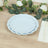 Light blue decorative plates stacked on a wooden table with greenery and flowers.