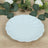 White scalloped serving plate on a wooden surface with greenery.