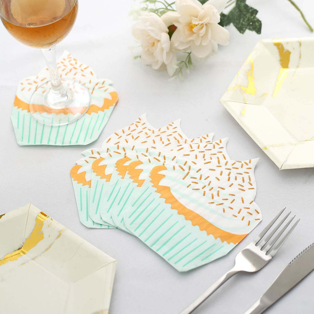 Colorful cupcake-shaped coasters on a table with elegant tableware.