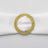 Gold beaded napkin ring on a white napkin.