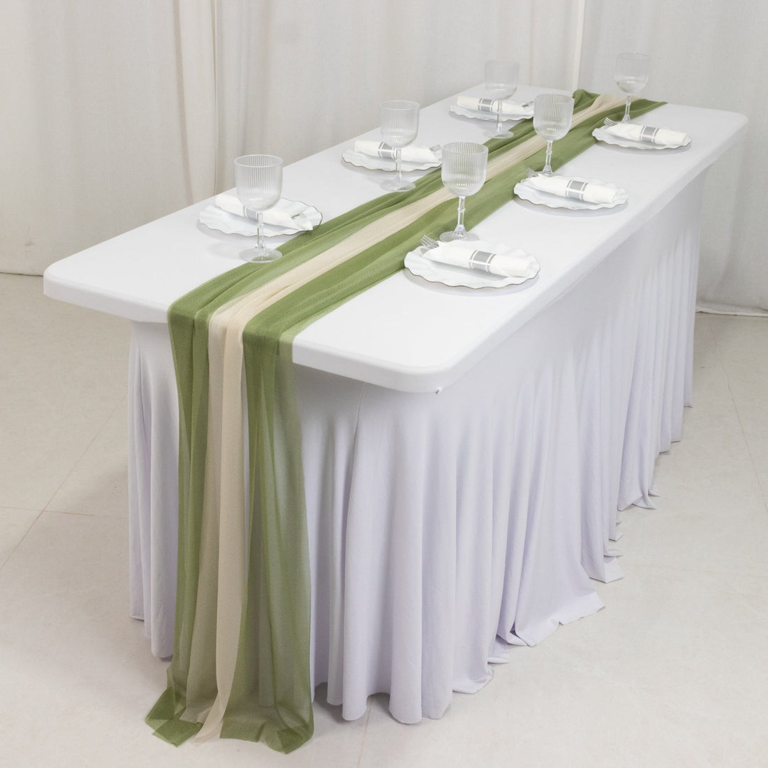 Elegant dining table setup with green and beige table runner and glassware.