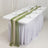Elegant dining table setup with green and beige table runner and glassware.