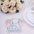 Cute elephant decoration with a crown, surrounded by roses and tableware.