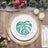 Decorative plate with a green monstera leaf design on an elegant table setting.
