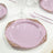 Elegant pink plate with gold ornate border on a table setting.