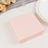 Pink paper napkins stacked on a table with a glass and plate.