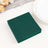 Green paper coasters stacked on a table with a plate and decorative elements.