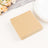 Brown paper napkins stack on a table with decorative elements.