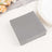 Gray linen napkins stacked on a table with decorative elements.