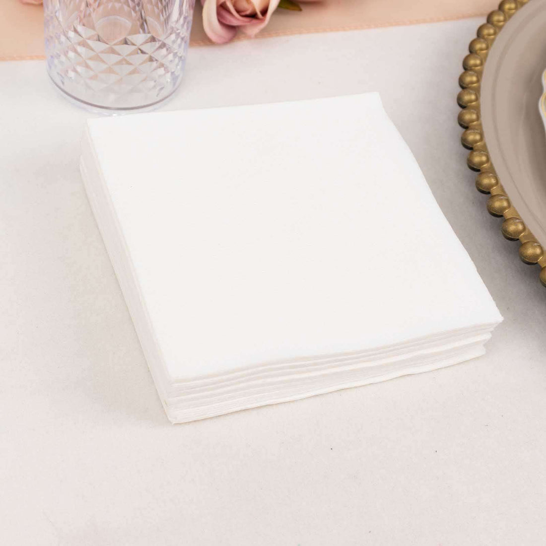 White napkins stacked on a table, perfect for events or dining.