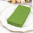 Stack of green craft paper on a decorative white plate.