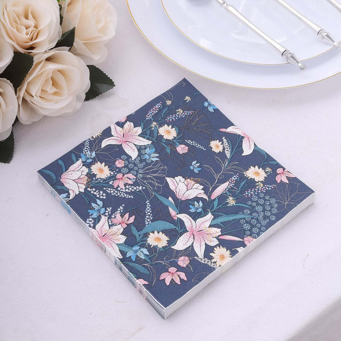 Floral patterned notebook on a table with plates and flowers.
