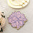 Floral-themed decorative plate with a gold outline and purple design on a table setting.