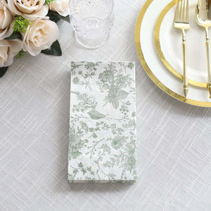 Floral patterned napkin on a table setting with gold utensils and glassware.