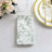 Floral patterned napkin on a table setting with gold utensils and glassware.