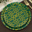 Green patterned plates with yellow geometric design, set on a dark surface.