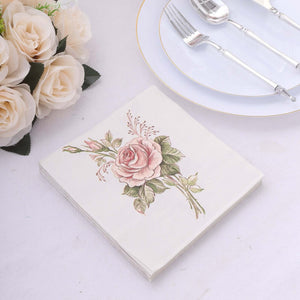 Floral design paper napkin on a table setting with silver cutlery and roses.