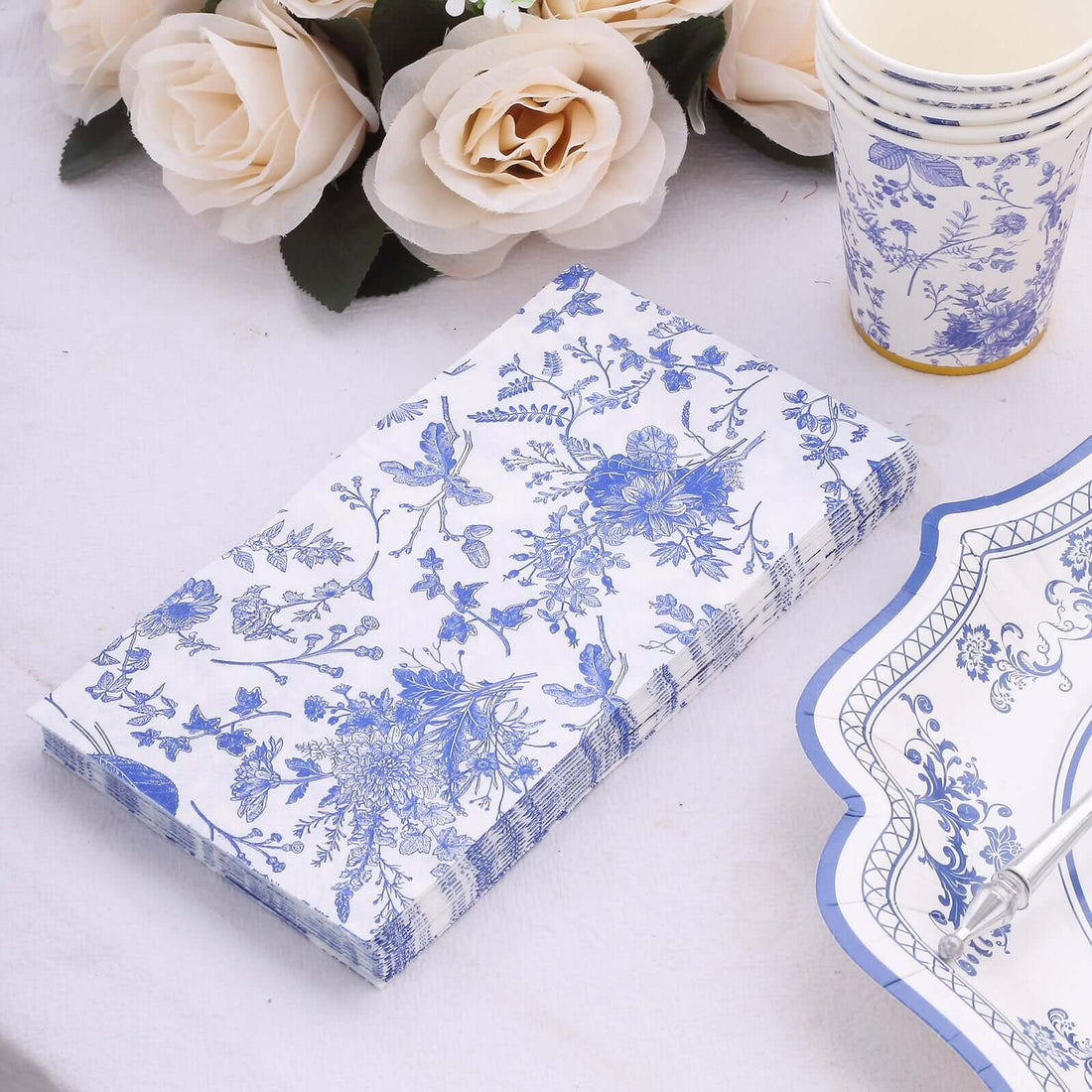 Blue floral paper napkins on a table with decorative items.