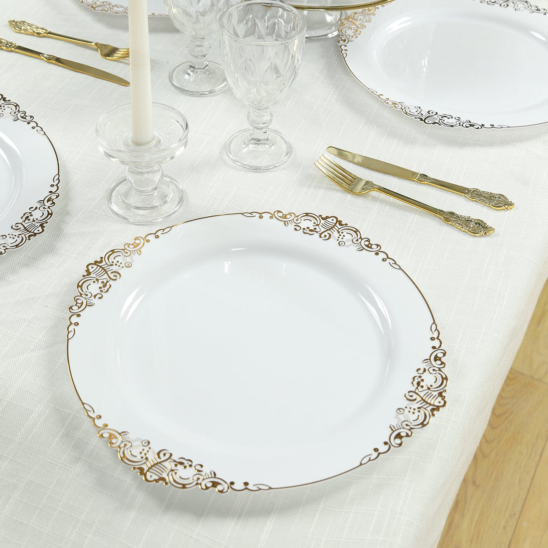 Elegant white plate with gold scroll design, set on a dining table.