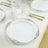 Elegant white plate with gold scroll design, set on a dining table.