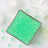 Green gel beads in a square container with decorative elements around it.