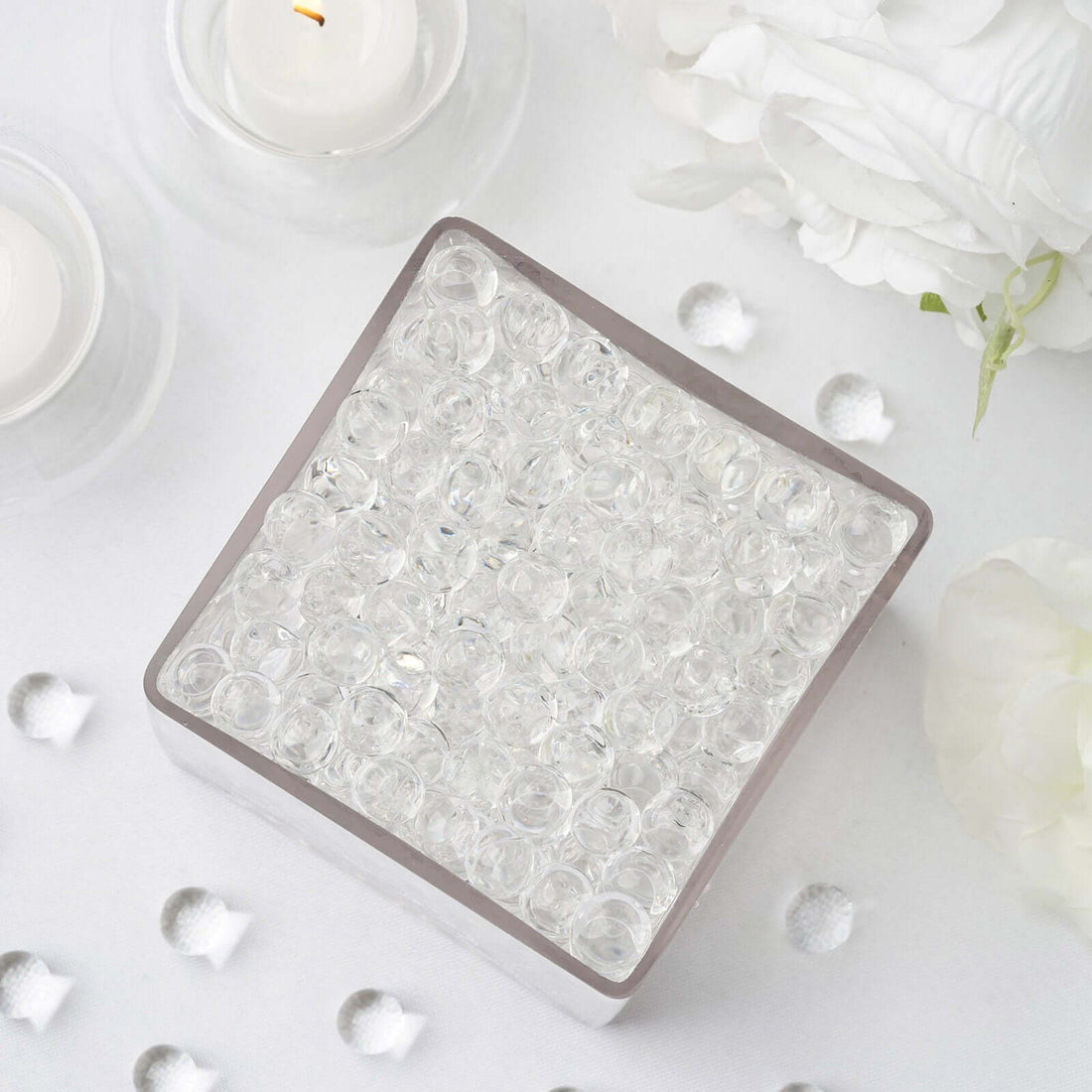 Clear glass decorative beads in a square container