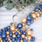 Colorful blue and gold decorative pearls spilling from a glass vase.