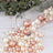 Assorted pearl beads spilling from a clear vase