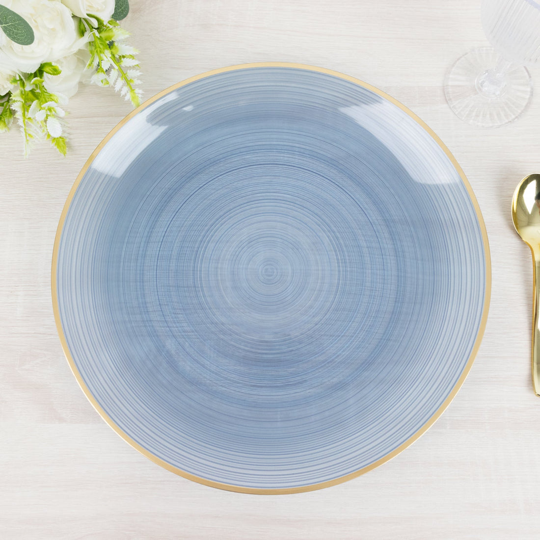 Blue ceramic plate with a gold rim on a light wooden surface.