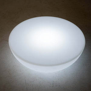 Round glowing white light fixture on a plain background