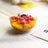 Fruit salad in a glass bowl with mango and pomegranate pieces.
