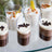 Dessert cups with layered chocolate and cream, garnished with toppings.