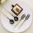 Elegant black and gold cutlery set with dessert on a white plate