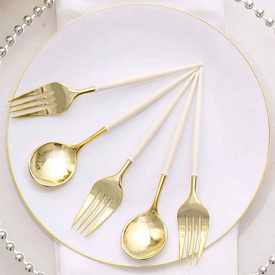 Elegant gold and white cutlery set arranged on a plate
