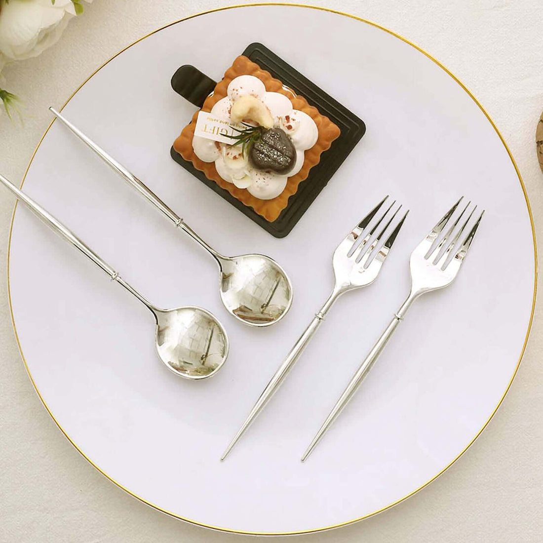 Elegant dessert plate with silver cutlery and gourmet cake.
