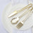 Gold cutlery set on a white plate with a napkin.