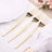 Three elegant gold forks on a table setting with floral accents.